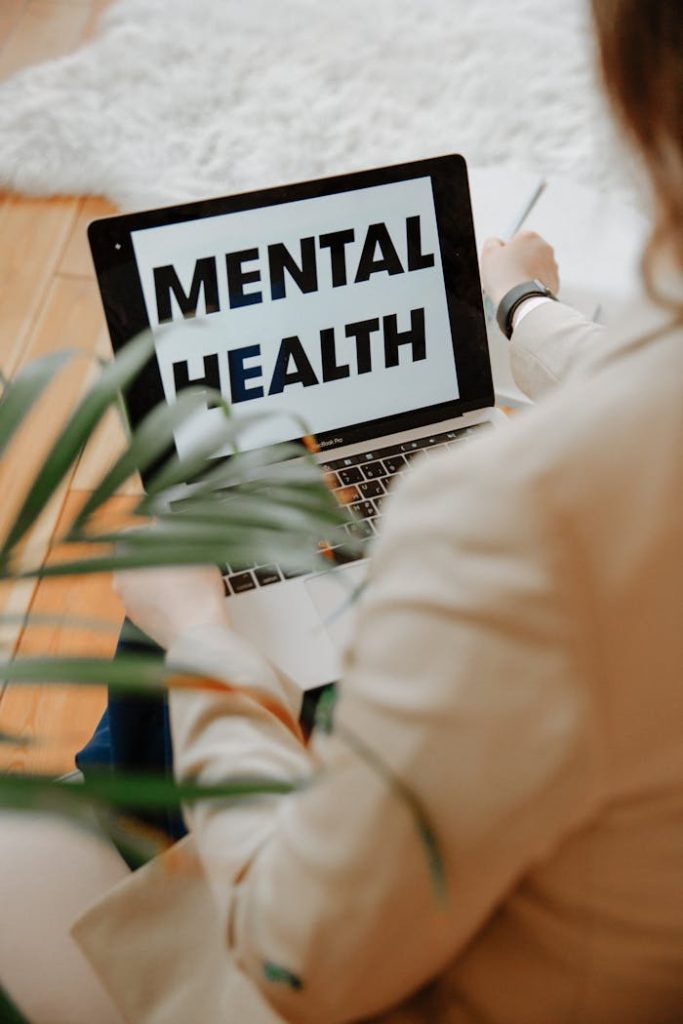 pexels photo 3958403 A woman focuses on mental health resources through her laptop in a home office setting.